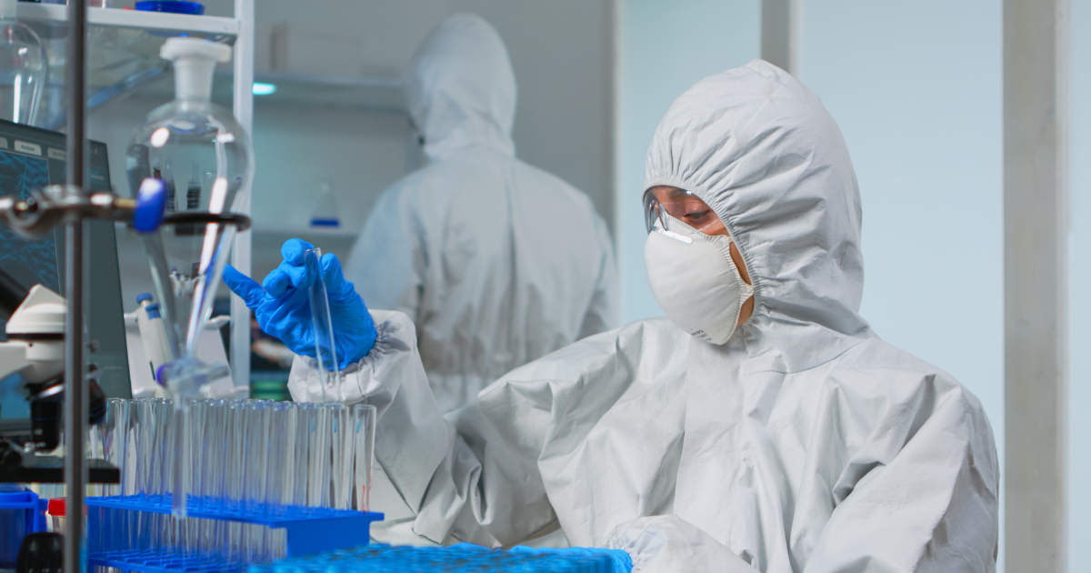 A woman wearing lab protective equipment while using butane for extraction.