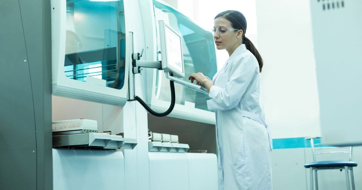 A female scientist calibrating lab equipment.
