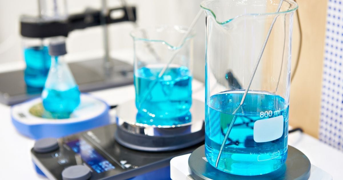 Two beakers on magnetic stirrers with a blue liquid inside.