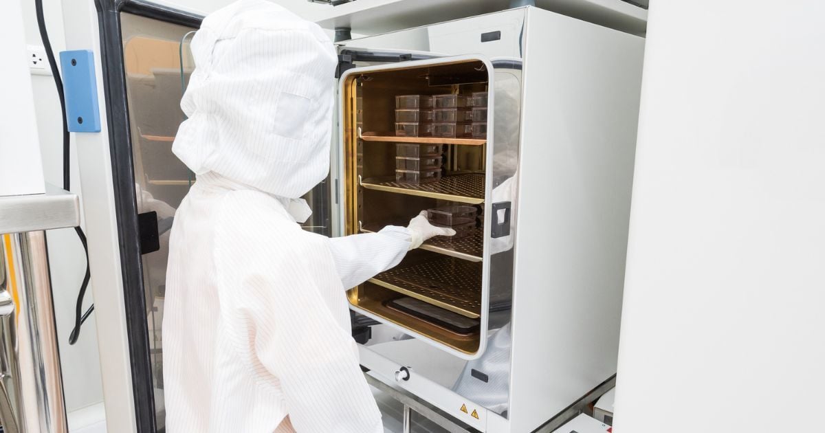 A research placing cell cultures into an incubator.