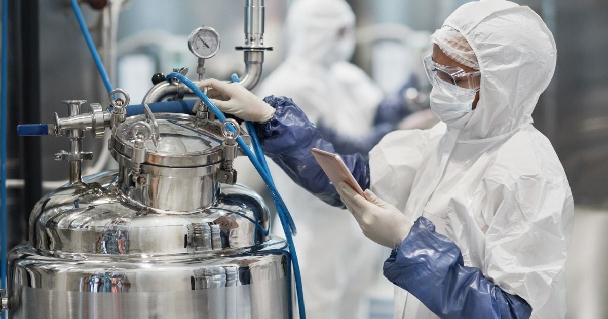 A woman scientist checking a lab tank for signs of residue.