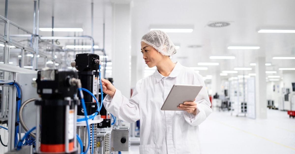 A lab tech checking equipment in a lab.