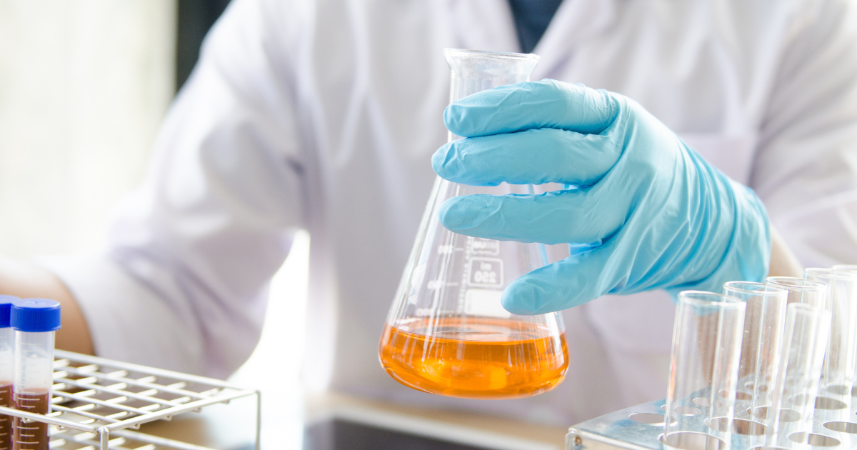 A scientish using a glass beaker to complete an experiment.