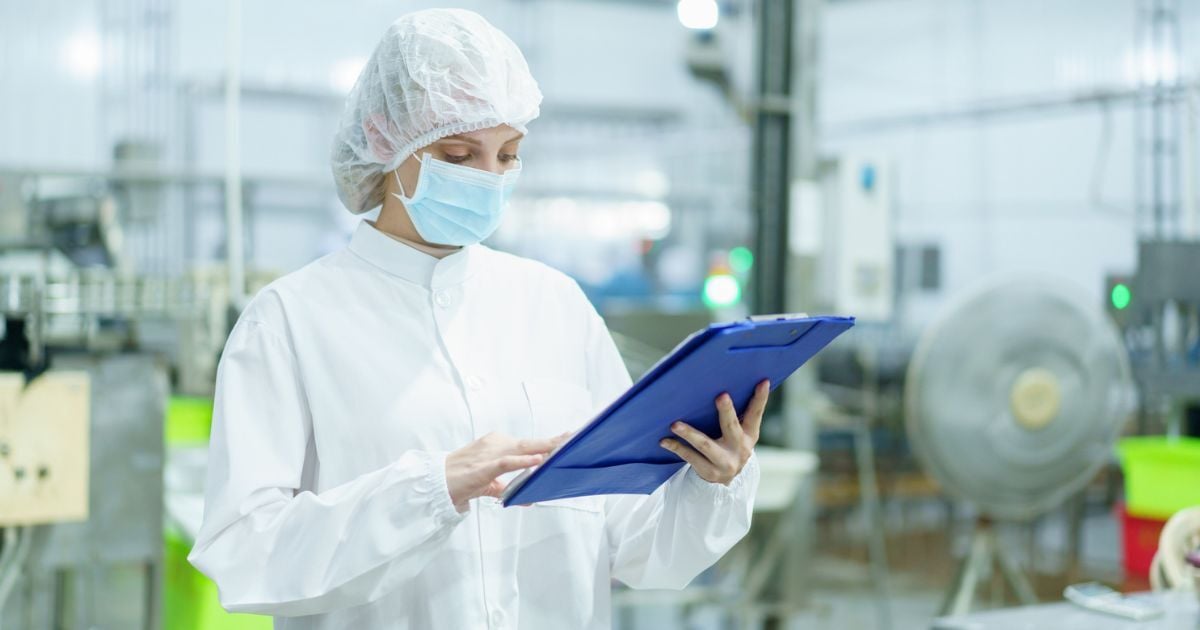 A lab inspector looks over the maintenace logs for their lab systems.