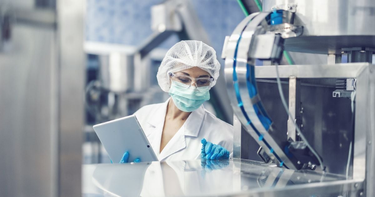 A woman inspecting lab equipment checking if they're following quality standards.