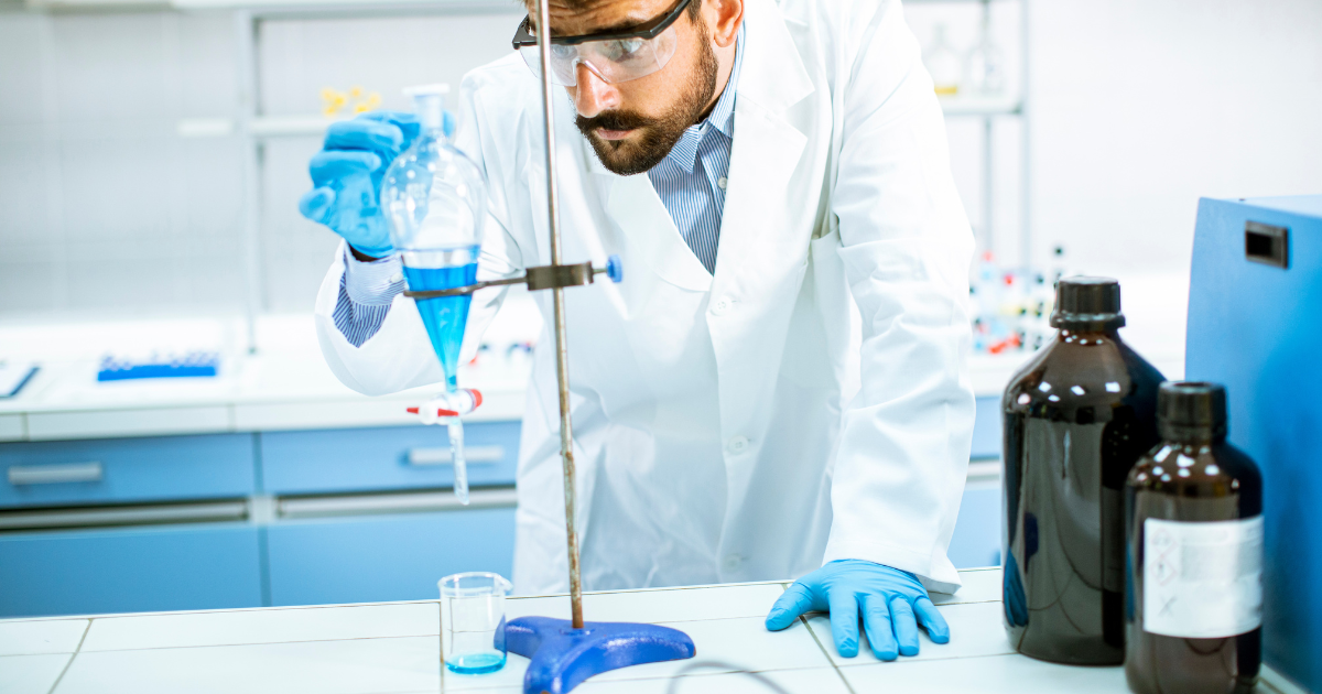 A lab tech using safety protocols while working in the lab.