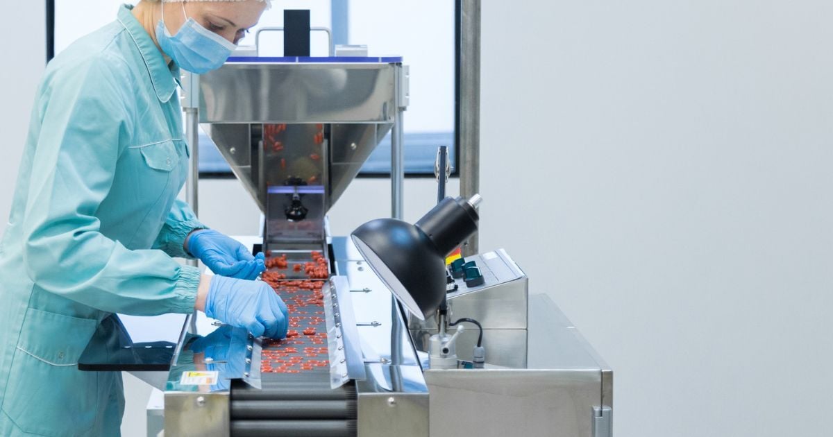 A scientist using a pill sorter in their pilot scale lab.