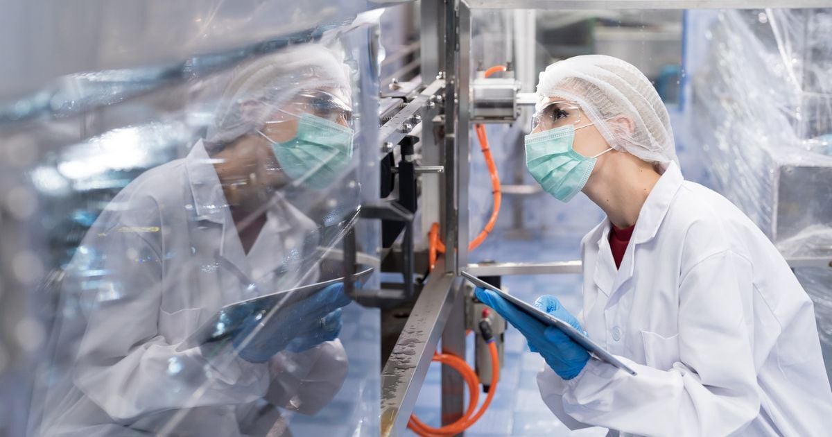 A woman inspecting equipment for quality and regulatory standards.